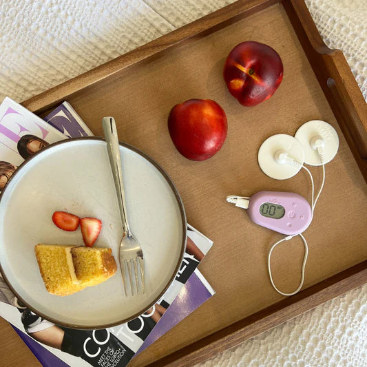 L'appareil Ellune sur un plateau de petit-déjeuner « Ellune a révolutionné mon quotidien ! Je souffre d'endométriose, d'adénomyose et de SOPK. J'avais des douleurs quotidiennes, et pas seulement pendant mes règles. Grâce à Ellune, j'ai pu réduire considérablement ma consommation de médicaments. » - Emily